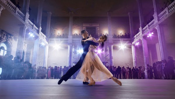 A ballroom dance couple performing in a grand hall